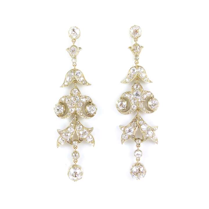 Diamond scroll cluster pendant earrings each hung with a cushion cut diamond collet
